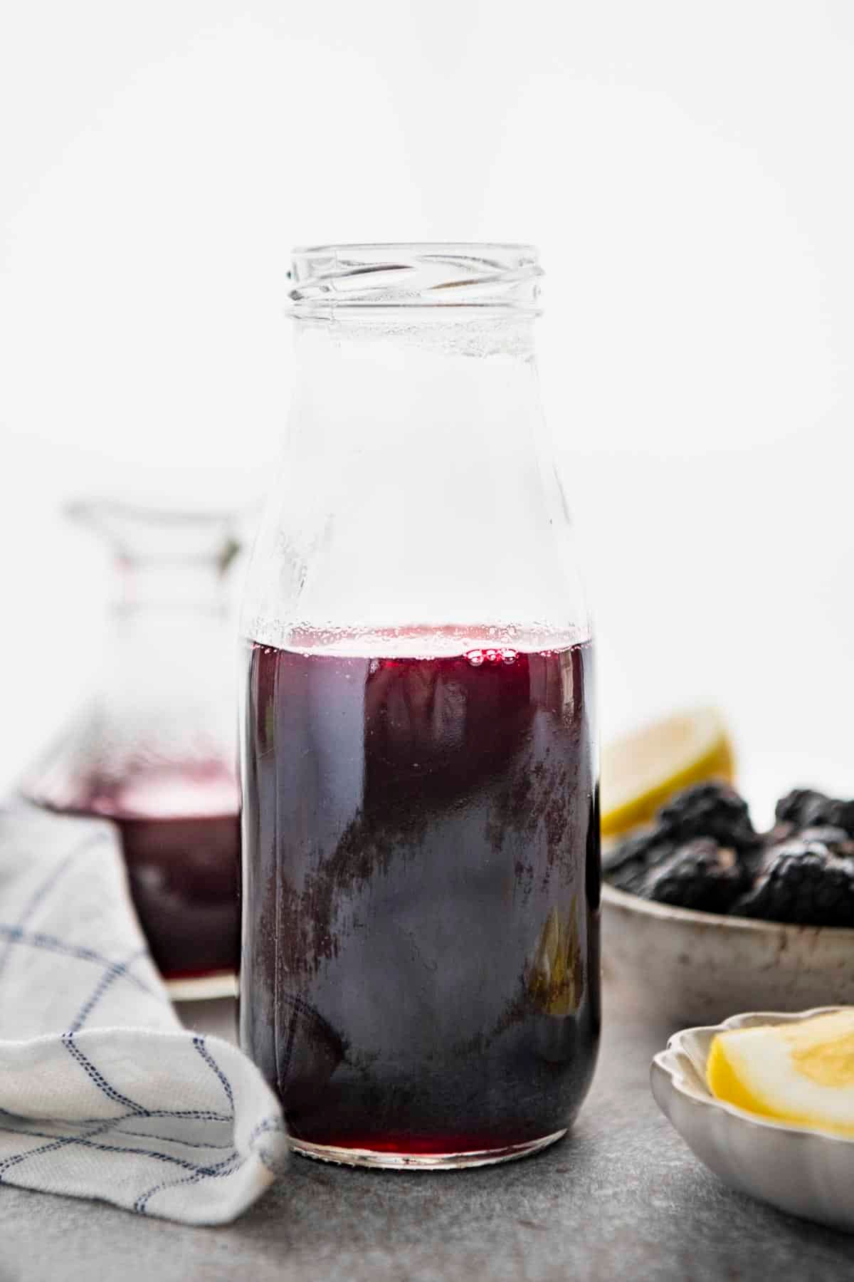 Homemade blackberry syrup recipe stored in a glass bottle.