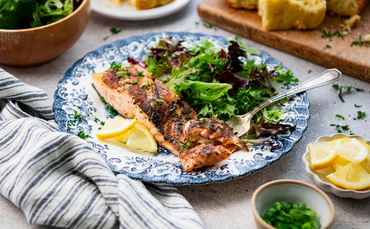 Horizontal side shot of a plate of the best grilled salmon recipe.