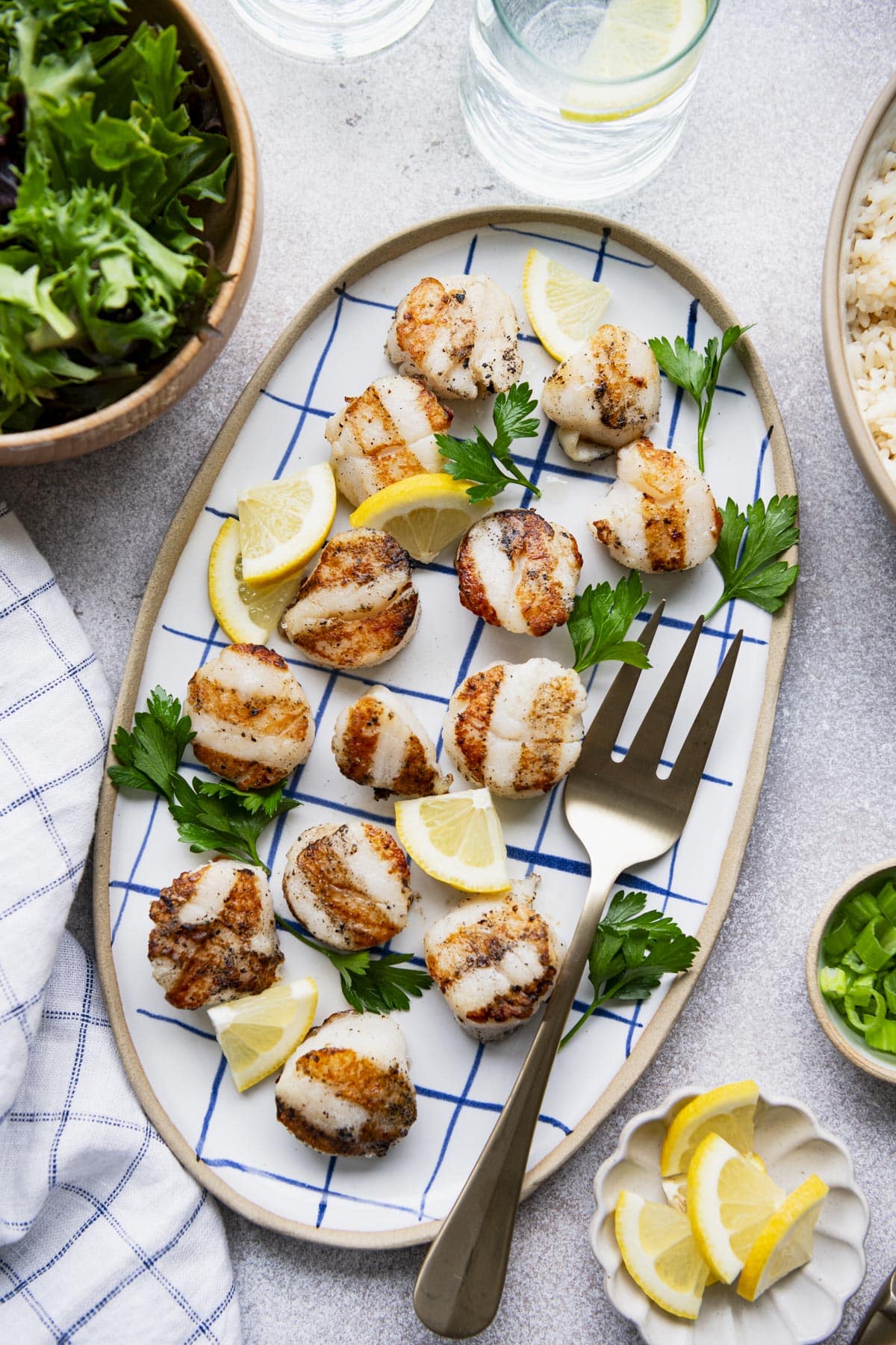 Overhead image of the best grilled scallops recipe on a blue and white tray.