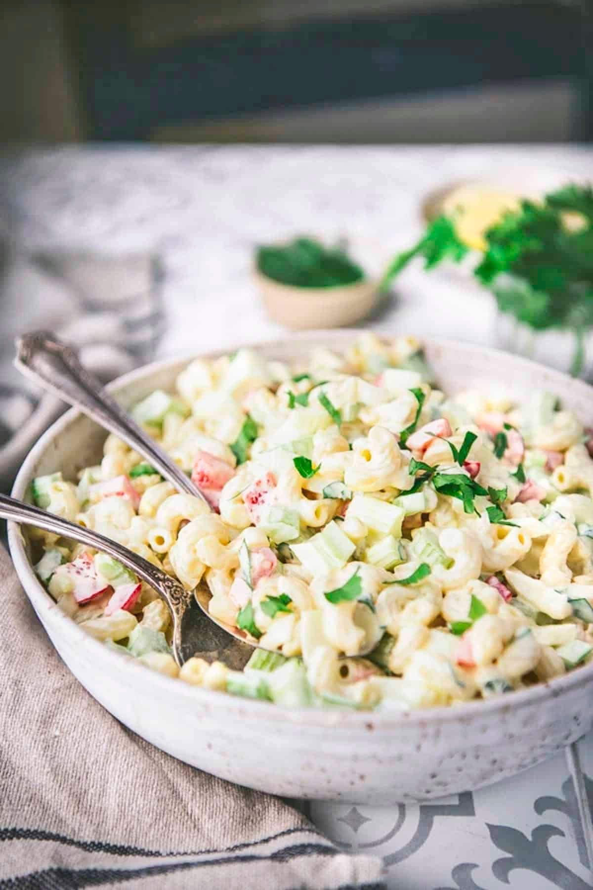 Close side shot of a traditional macaroni salad recipe in a bowl.