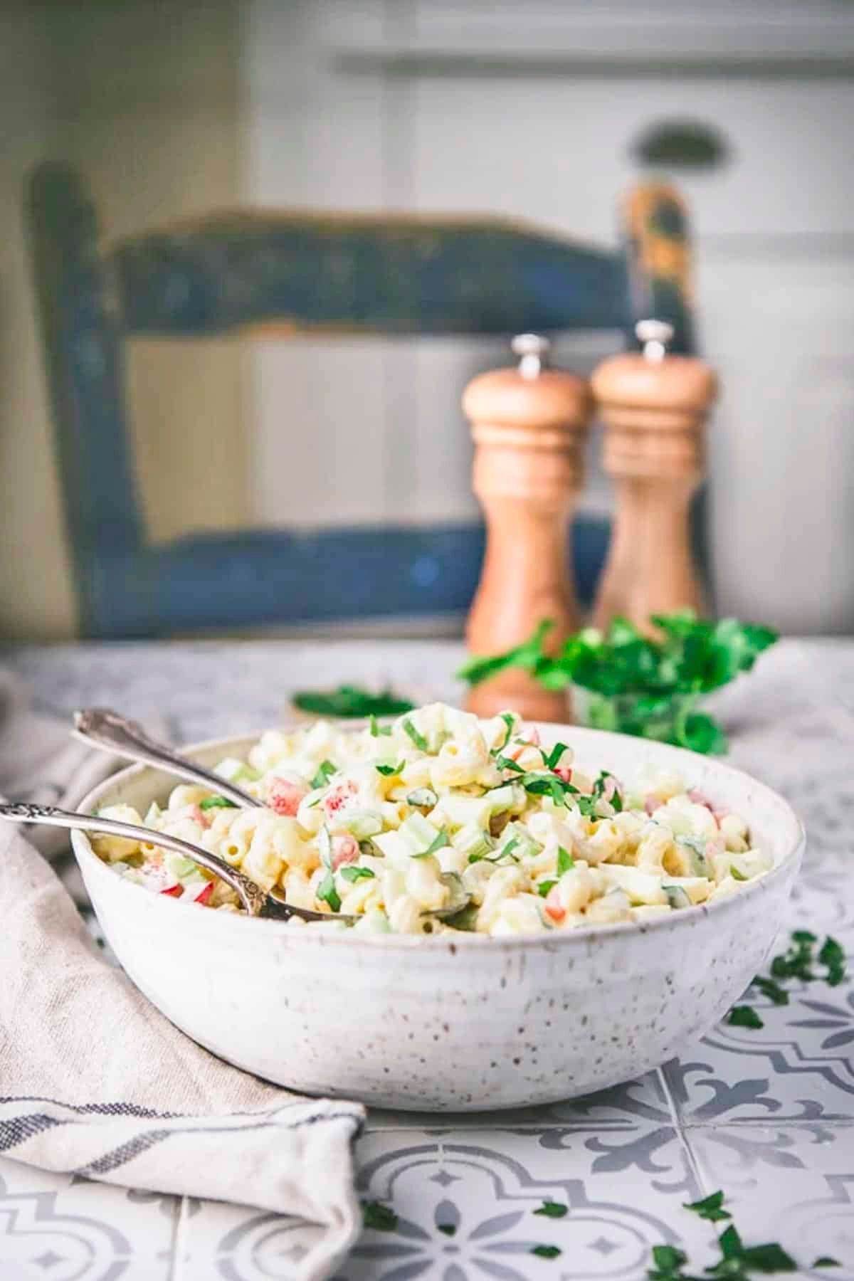 Side shot of a bowl of southern macaroni salad on a table.