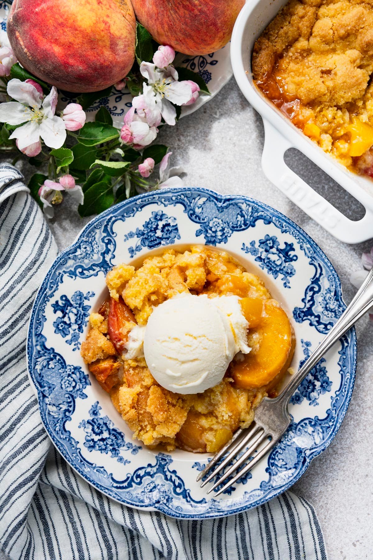 Overhead shot of a bowl of a southern peach cobbler recipe served in a blue and white bowl.