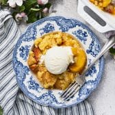 Square overhead shot of old fashioned southern peach cobbler in a bowl.