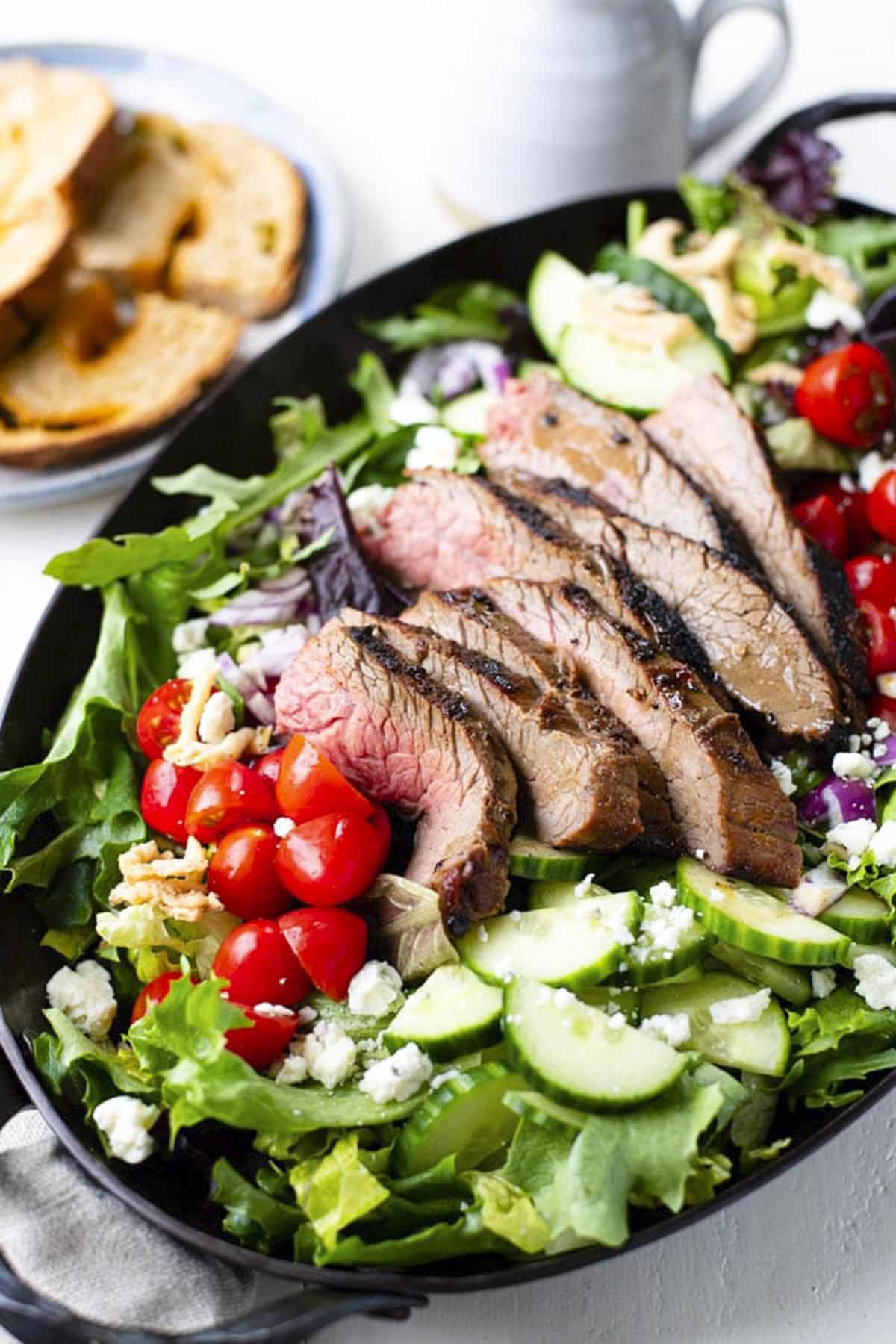 Close up front shot of a tray of grilled steak salad.