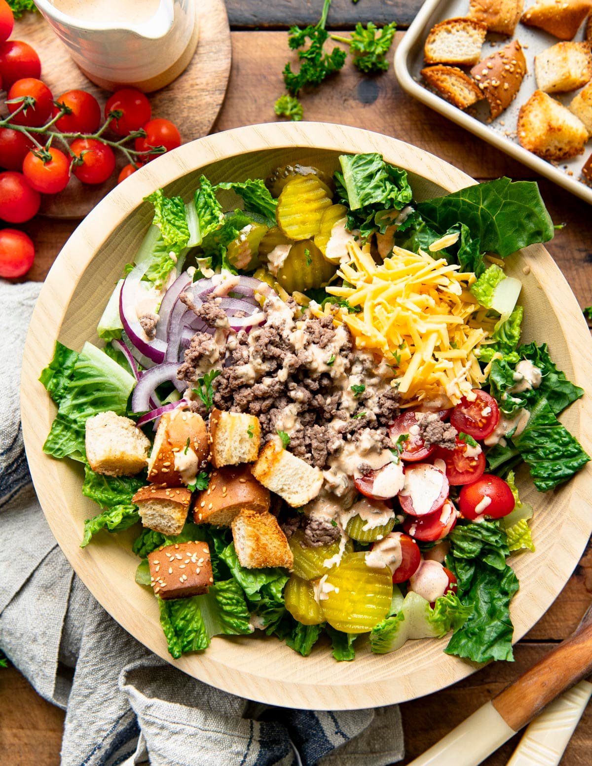 Overhead shot of the best big mac salad recipe served on a rustic wooden table.