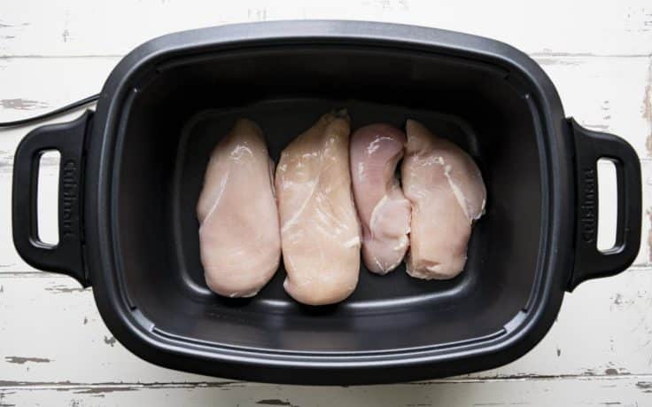 Boneless skinless chicken breasts in a slow cooker.