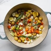 Vegetables and potatoes with fresh herbs and garlic in a Dutch oven.