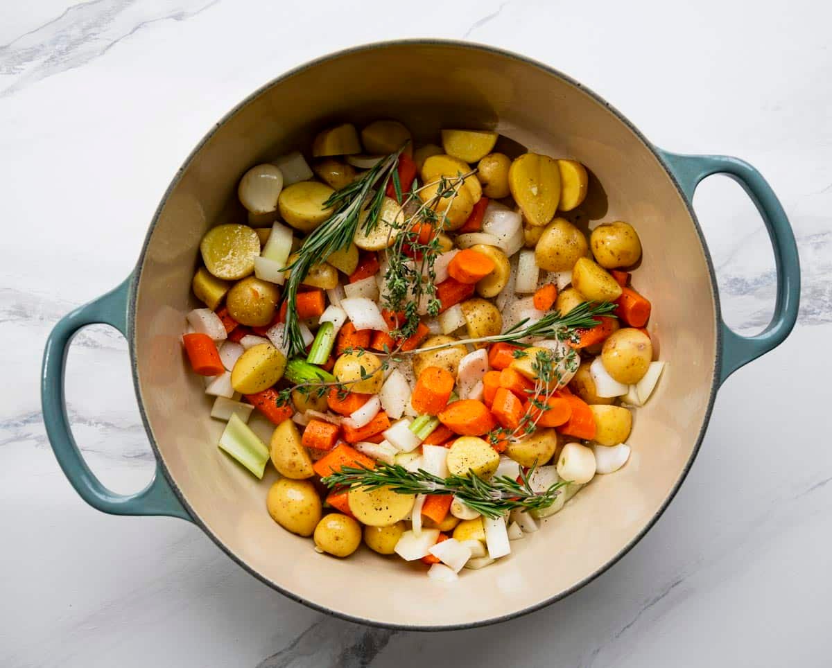 Vegetables and potatoes with fresh herbs and garlic in a Dutch oven.