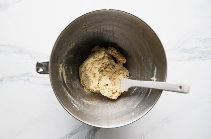 Butter and sugar creamed together in a metal mixing bowl.