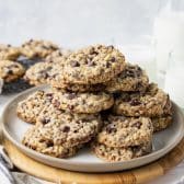 Square side shot of a plate of kitchen sink cookies on a white table.