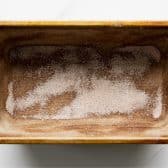 A loaf pan dusted with cinnamon sugar.