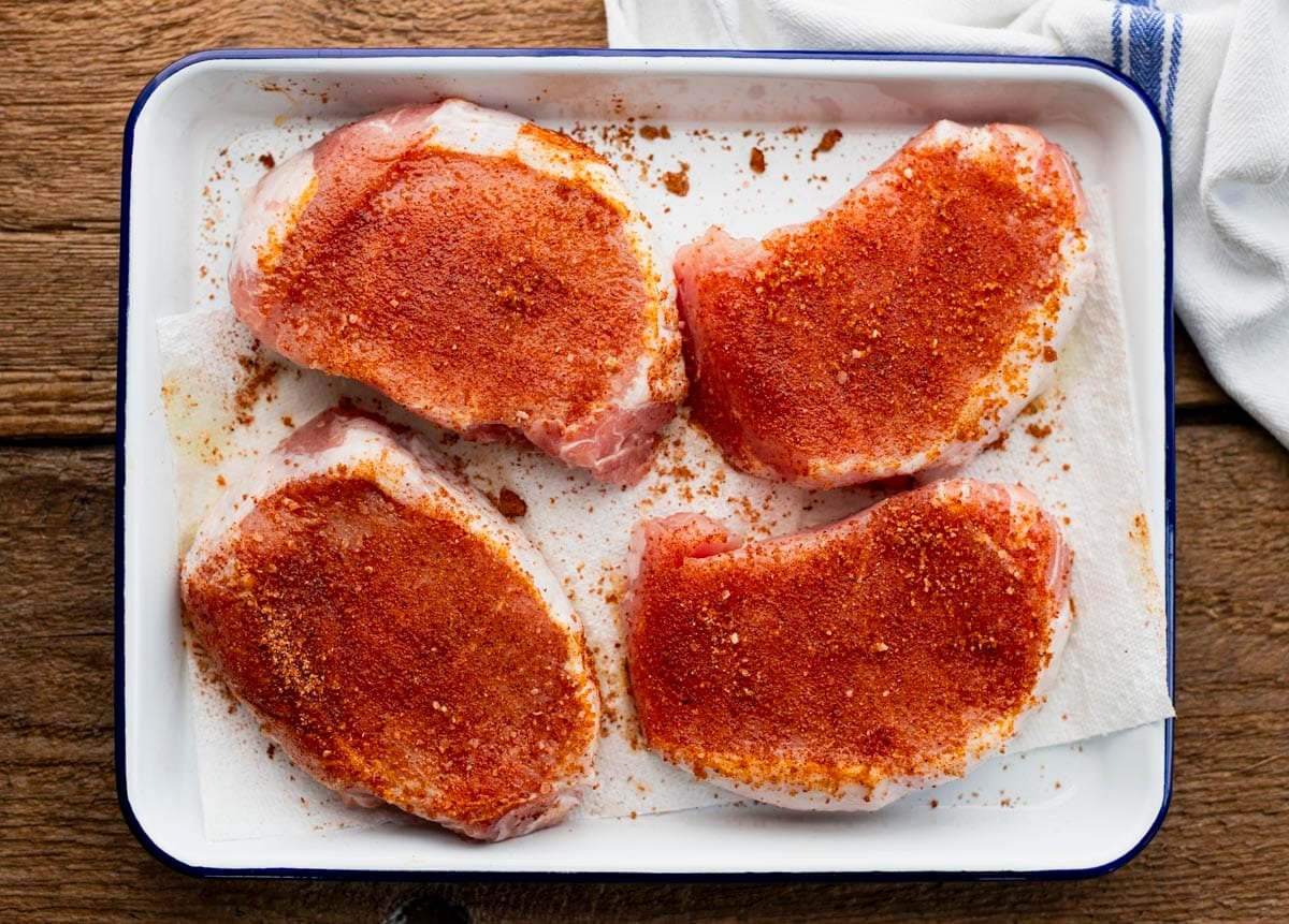 BBQ dry rub on pork chops before grilling.