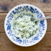 Garlic and herb butter in a blue and white dish.