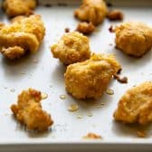 Baked chicken nuggets on a baking sheet.