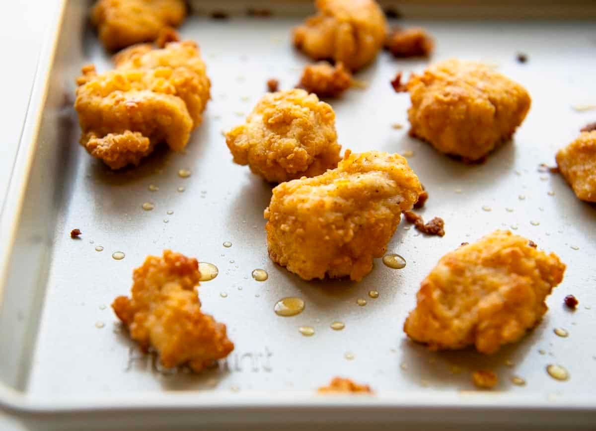 Baked chicken nuggets on a baking sheet.
