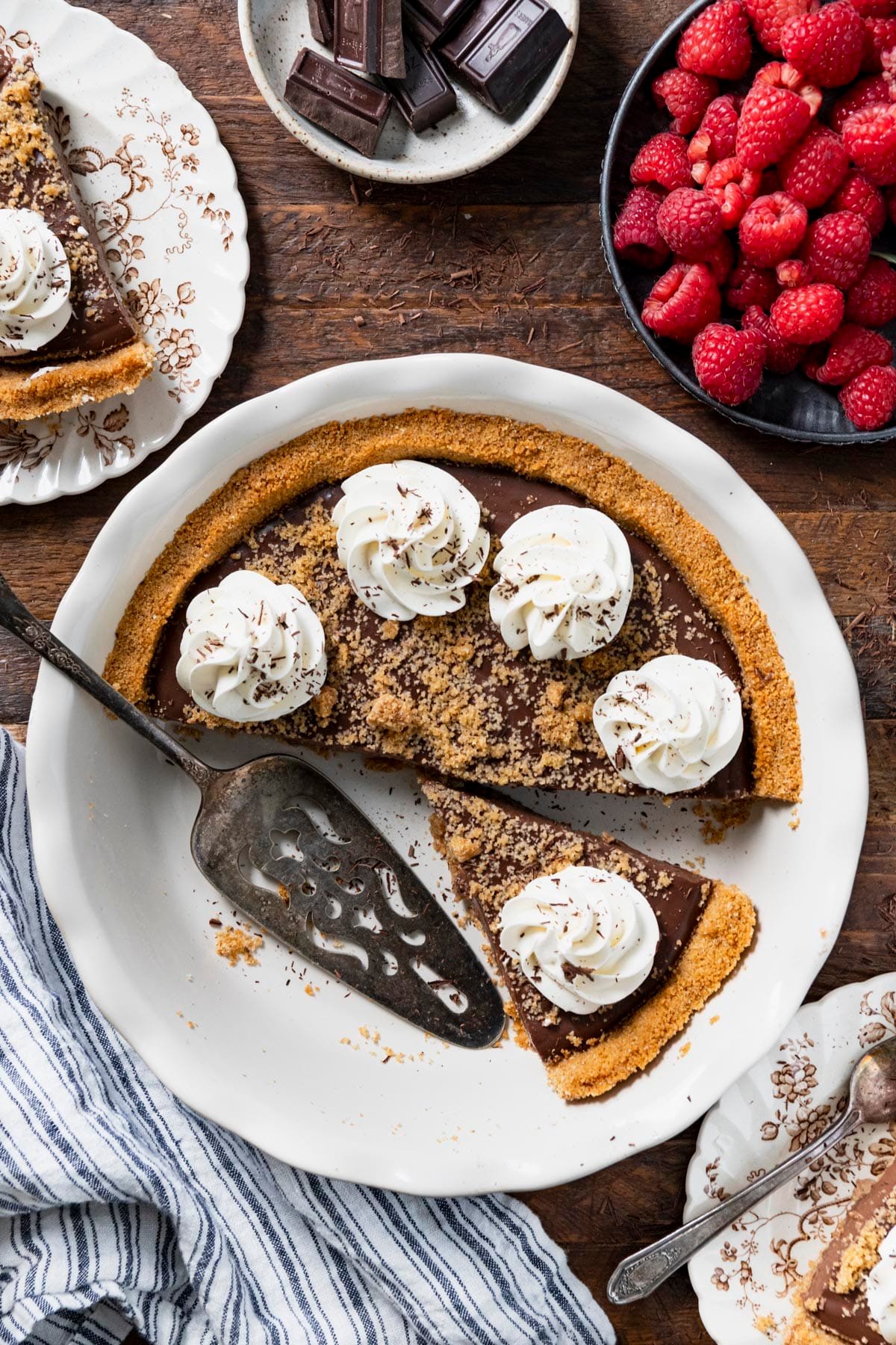 Overhead image of chocolate pudding pie in a white dish on a rustic wooden table.