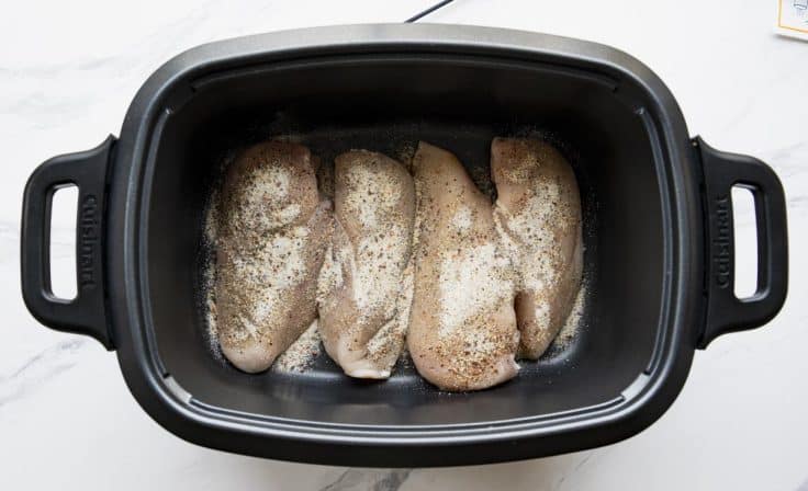 Chicken breasts with italian dressing mix seasoning in a slow cooker.