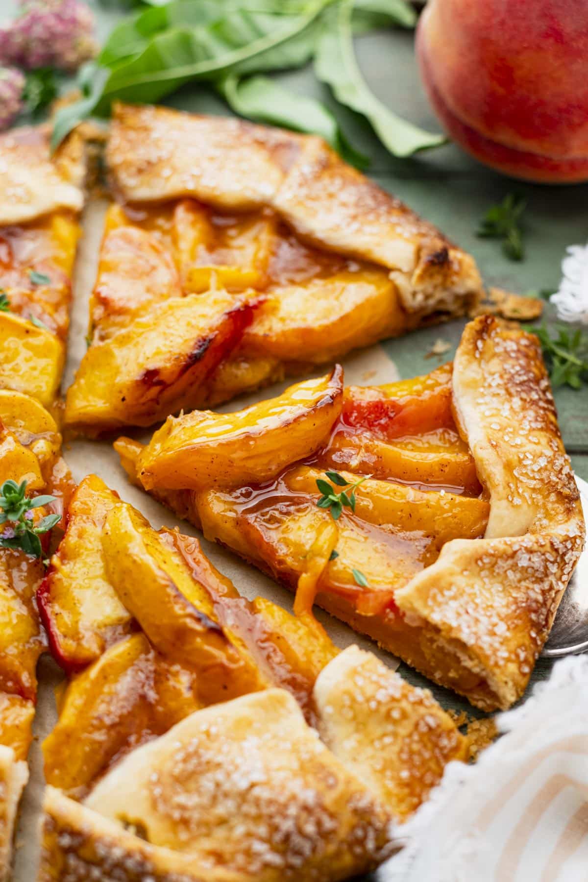 Close up side shot of a slice of easy peach galette on a server.