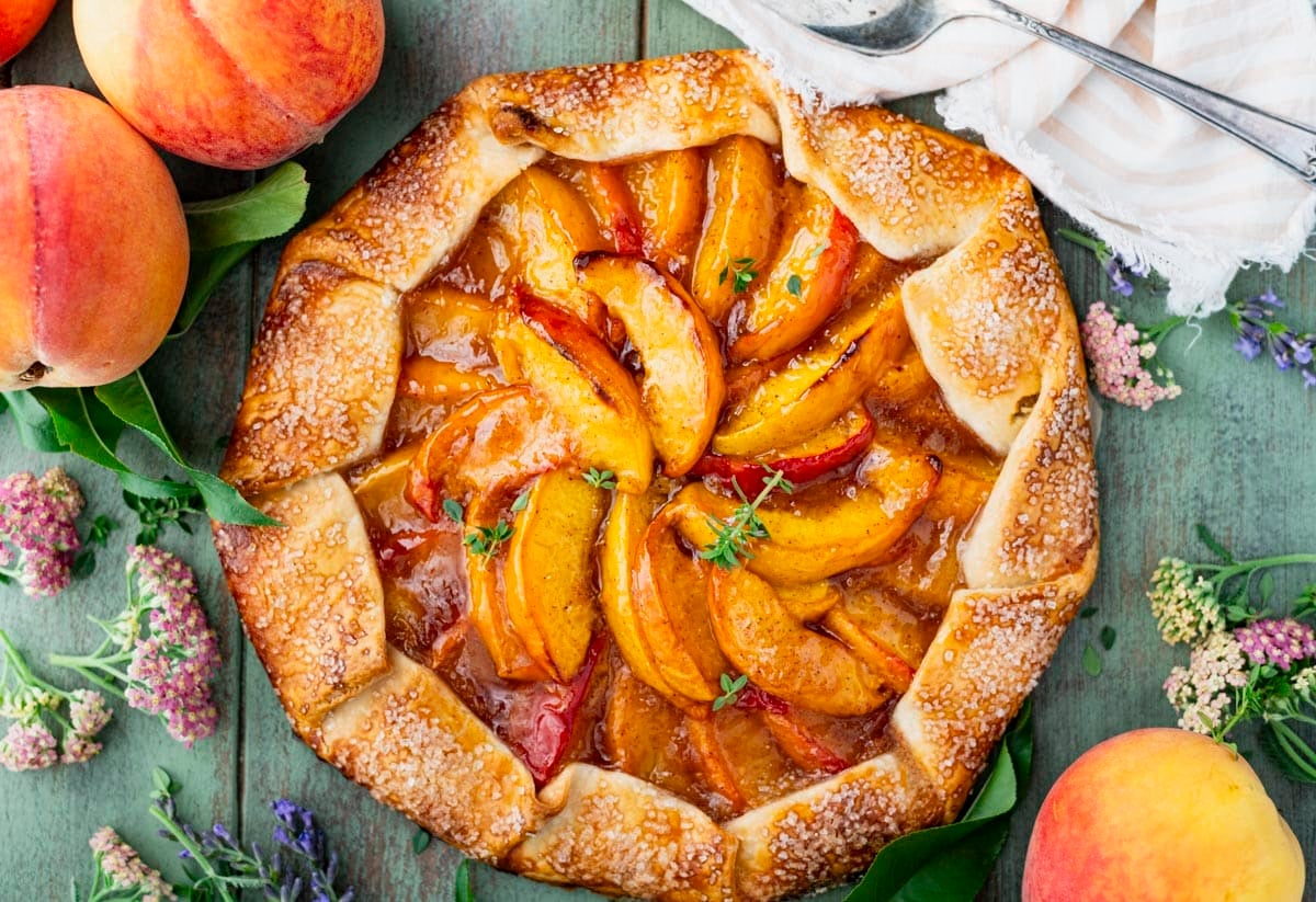 Horizontal overhead image of an easy peach galette recipe before it's sliced.