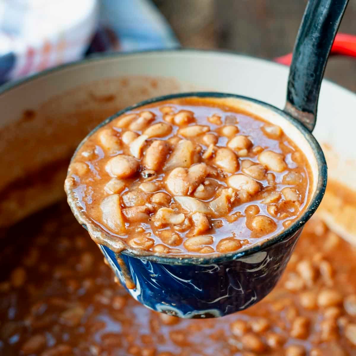Square close up shot of ranch style beans in a ladle.