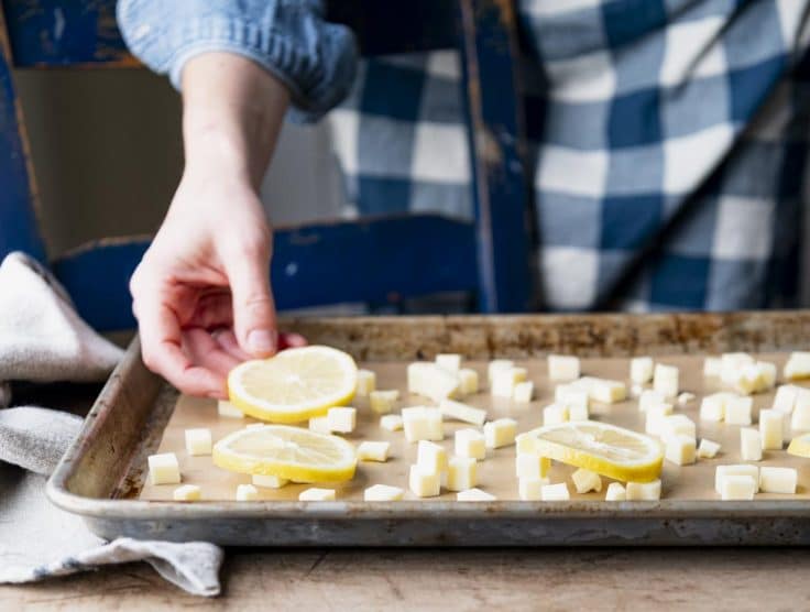 Arranging sliced lemons and diced butter on a sheet pan.