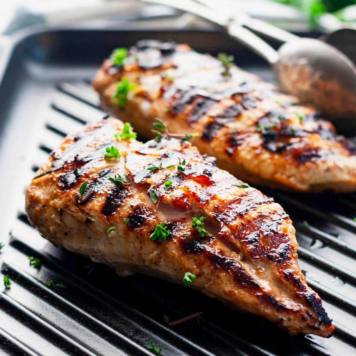 Square side shot of simple grilled chicken marinade on chicken breasts on a grill pan.
