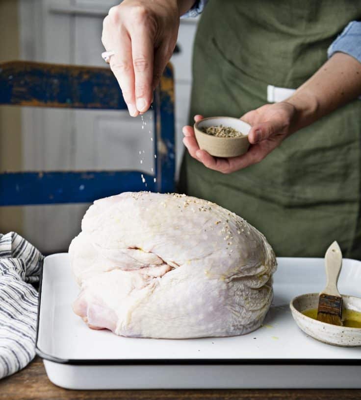 Process shot showing how to season turkey breast.