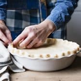 Process shot showing how to crimp pie crust for chicken pot pie.