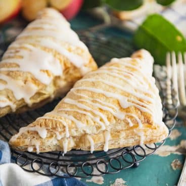 Square shot of easy apple turnovers with puff pastry on a wire rack.