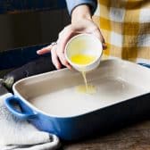 Pouring butter into a baking dish.