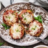 Horizontal overhead image of Grandma's baked eggplant parmesan recipe on a rustic wooden table.