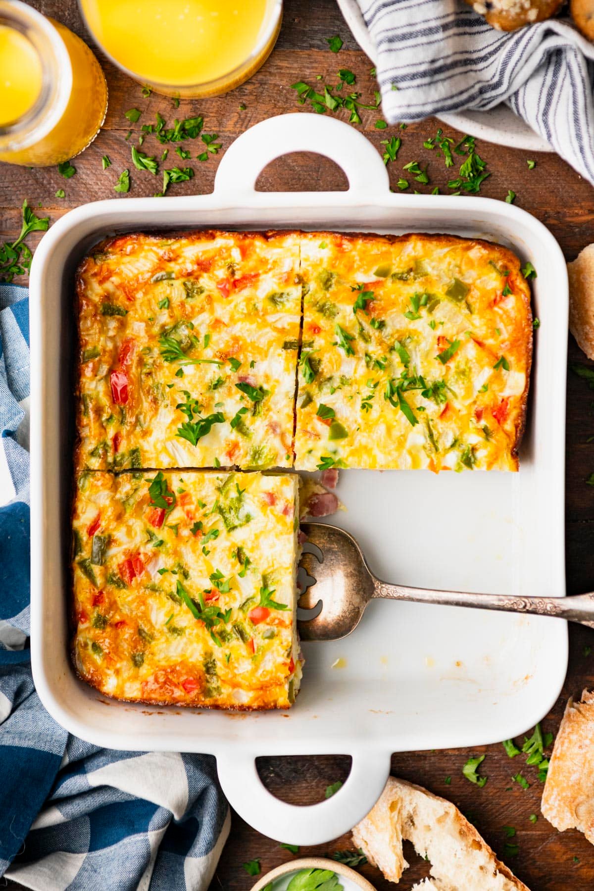 Overhead shot of a baked western omelet sliced into squares in a white dish.