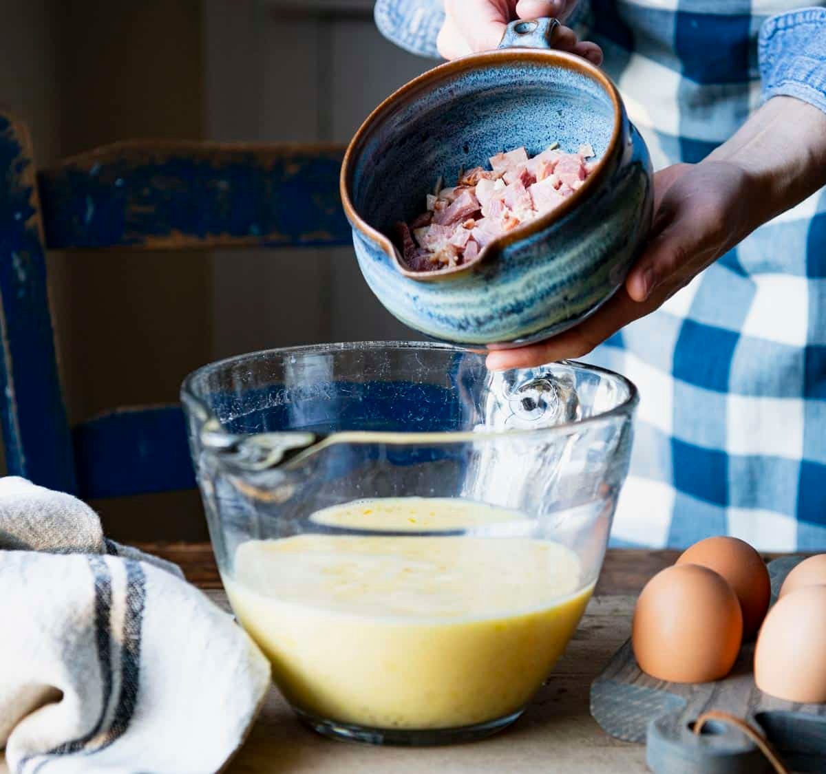 Adding ham to scrambled egg mixture.