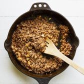 Taco seasoned ground beef in a cast iron skillet.