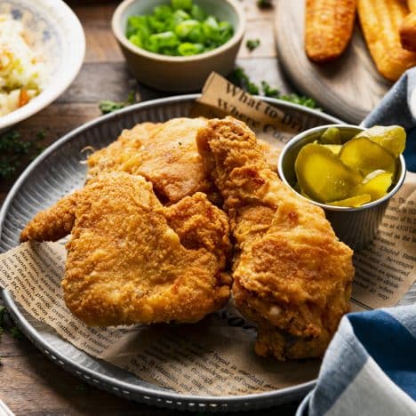 Square side shot of crispy fried chicken on a metal serving tray.