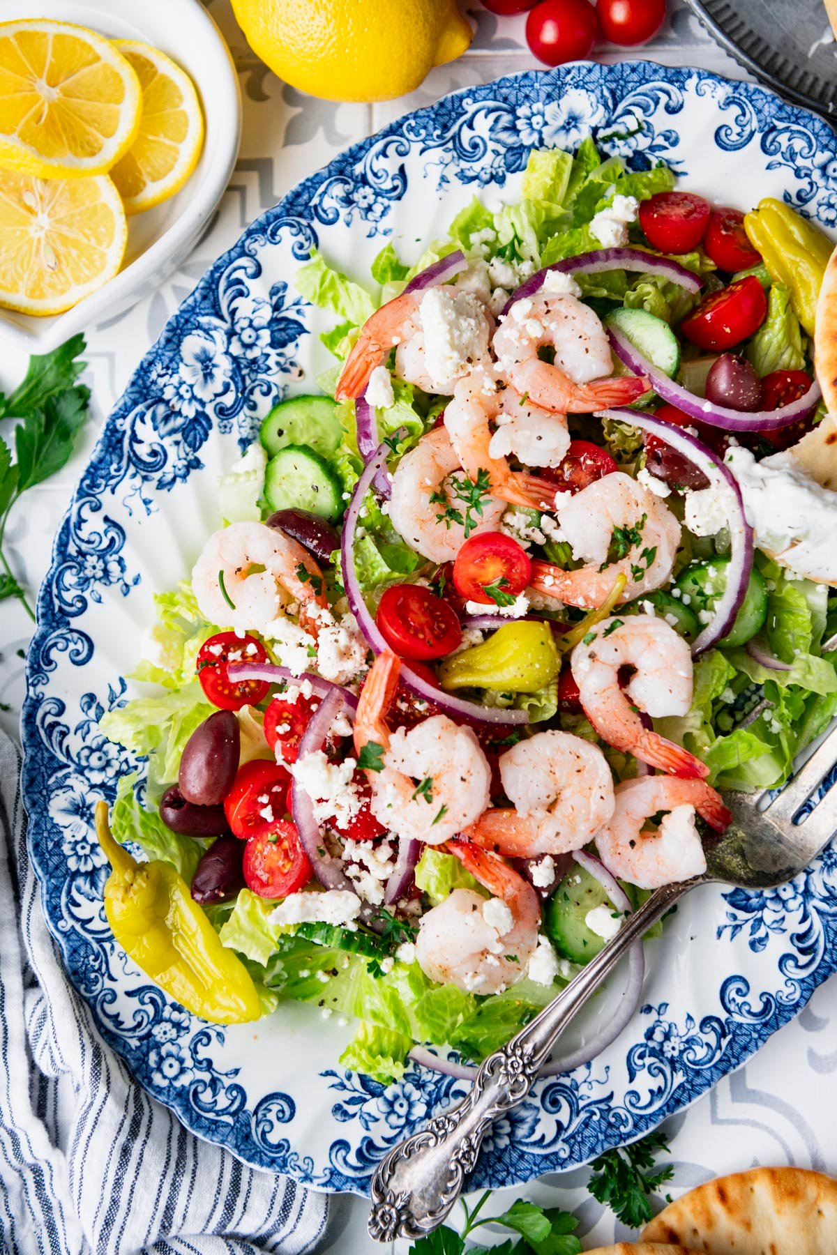 Close overhead shot of a blue and white platter of greek shrimp salad.