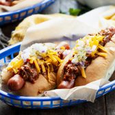 Chili dogs with hot dog chili sauce, cheese, relish, and other toppings.