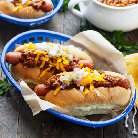 Square side shot of hot dogs with chili sauce in a basket.