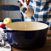 Pouring water and other ingredients into a dutch oven.