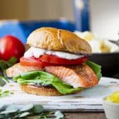 Horizontal side shot of an easy salmon sandwich on a dinner table.