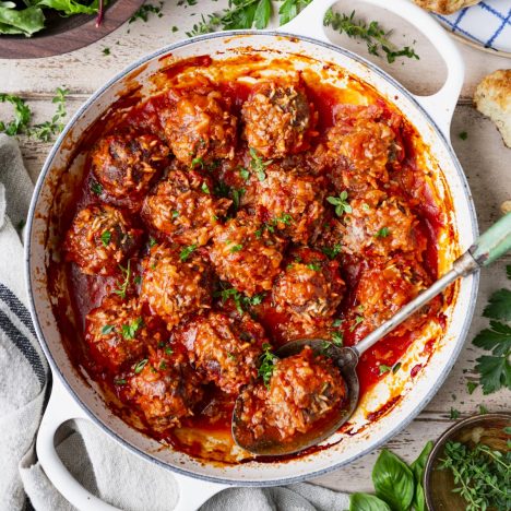 Square overhead shot of baked porcupine meatballs with tomato soup in a skillet.